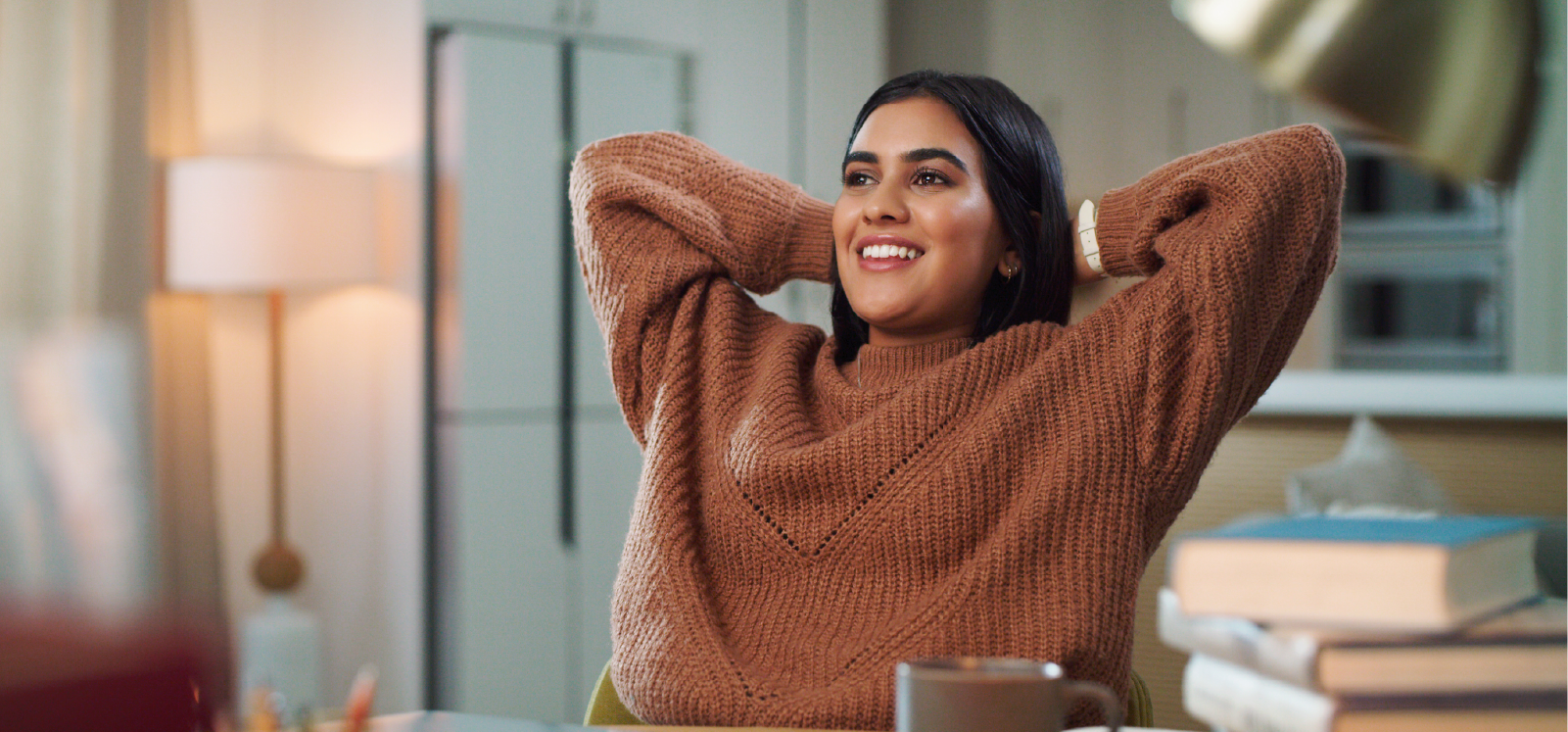 IMAGE: Woman smiling with hand behind head inside home