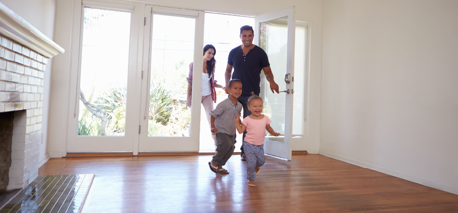 IMAGE: Family smiling and walking into empty, new home