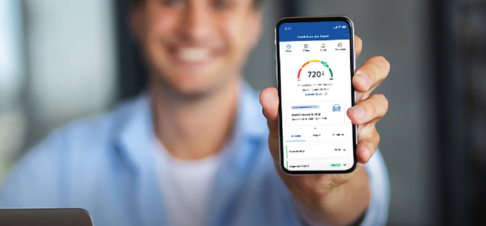 IMAGE: Smiling man holding a phone with SavvyMoney's Credit Score displayed