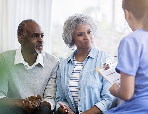 IMAGE: Couple sitting on a couch listening to a health care professional