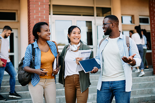 IMAGE: Group of 3 college students talking while walking around campus
